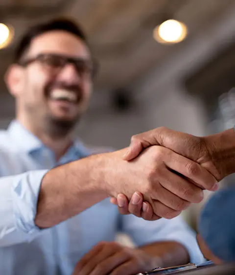 Business owner shaking hands with client after resolving an unpaid business debt